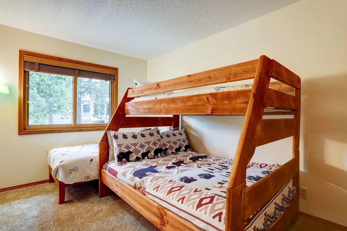 A welcoming bedroom with a bunk bed, window, and decorative pillows that add a playful touch. The space is bright and designed for comfort, ideal for kids or friends sharing a room.