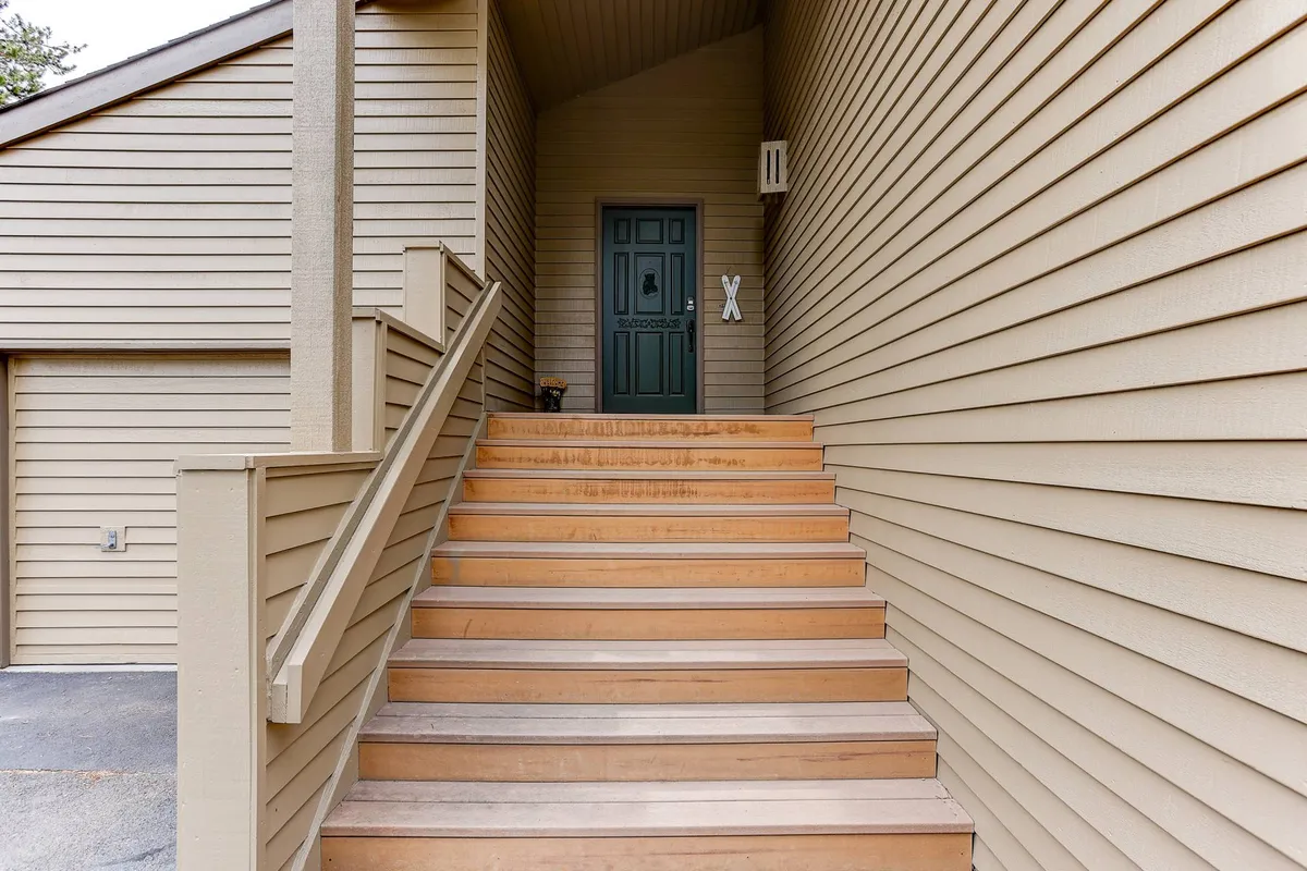 This exterior shot highlights the front entrance of 1 Shagbark, showcasing the inviting stairs, welcoming front door, and distinctive exterior siding. The image sets the tone for a private, standalone home while hinting at the warmth inside.
